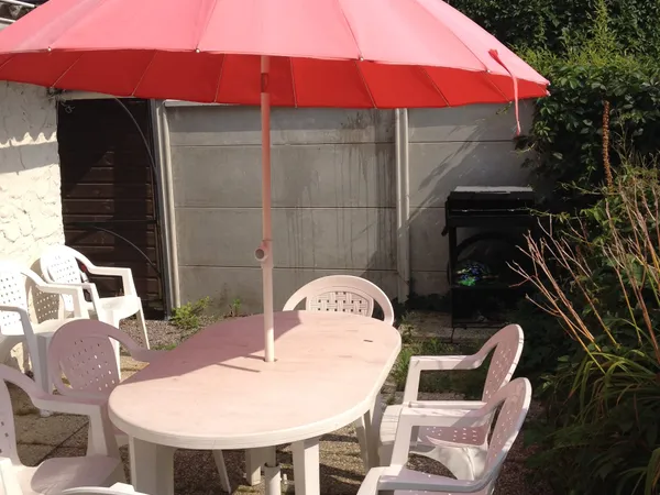The terrace with garden furniture and parasol